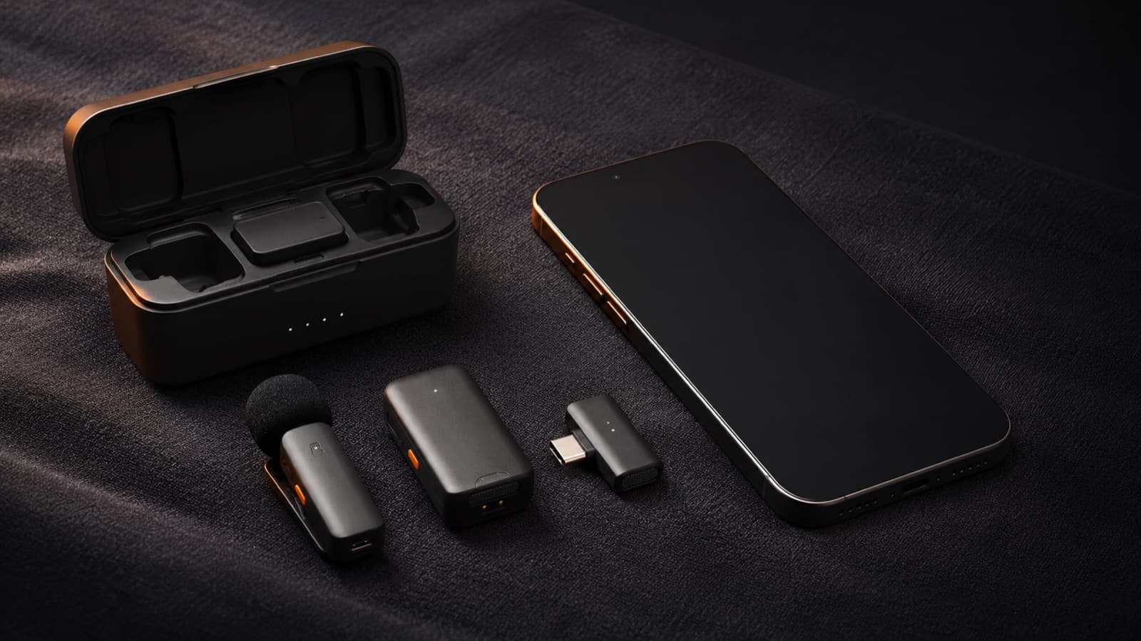 Microfone de lapela sem fio (case, transmissor e receptor USB-C) ao lado de um celular