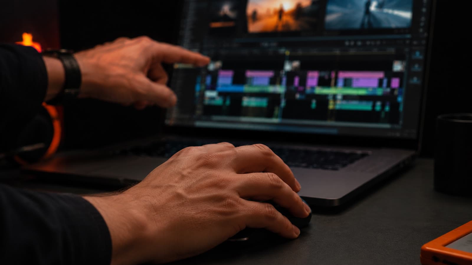 Mãos no mouse apontando uma timeline de edição com vários cortes