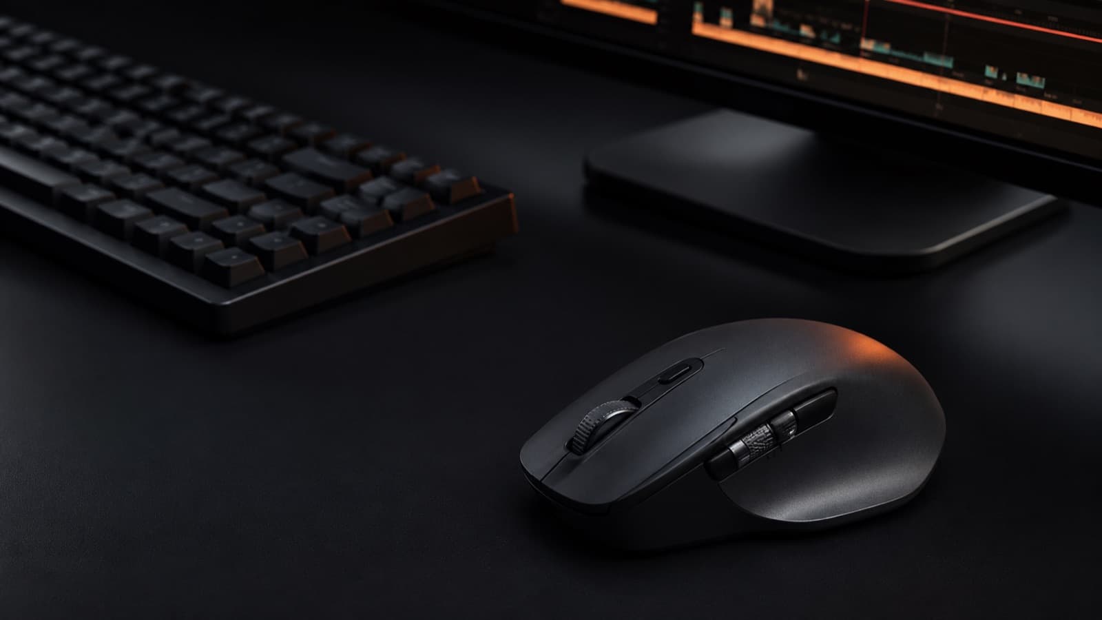 Mesa de edição escura com teclado mecânico, monitor com timeline e um mouse de produtividade com controles laterais em foco
