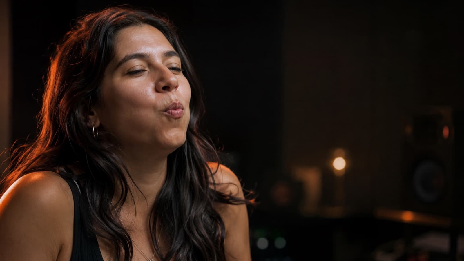 Pessoa fazendo vibração de lábios (“brrr”) de aquecimento vocal num cantinho de gravação