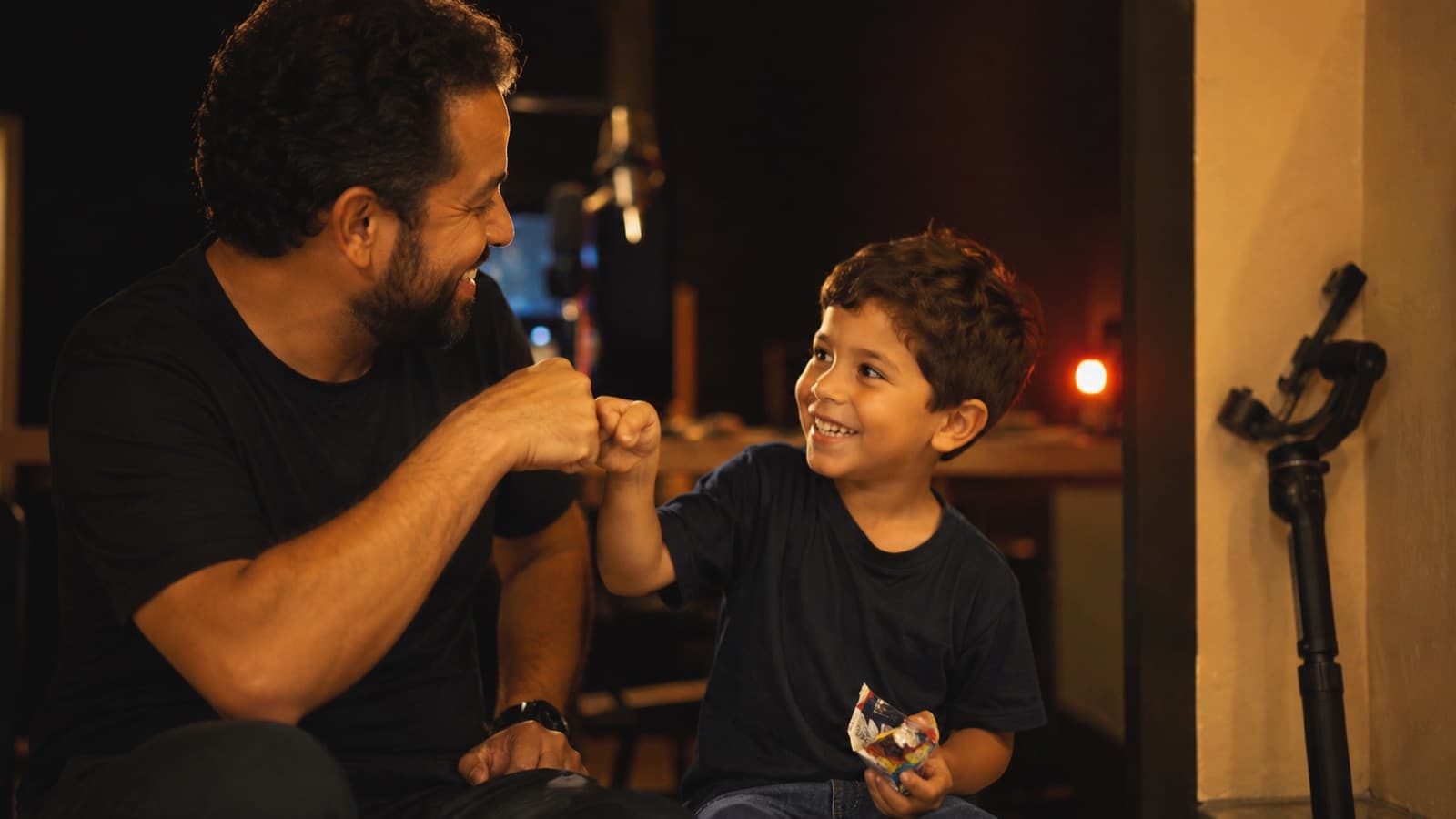 Adulto comemorando com a criança depois da gravação — toca-aqui e um prêmio