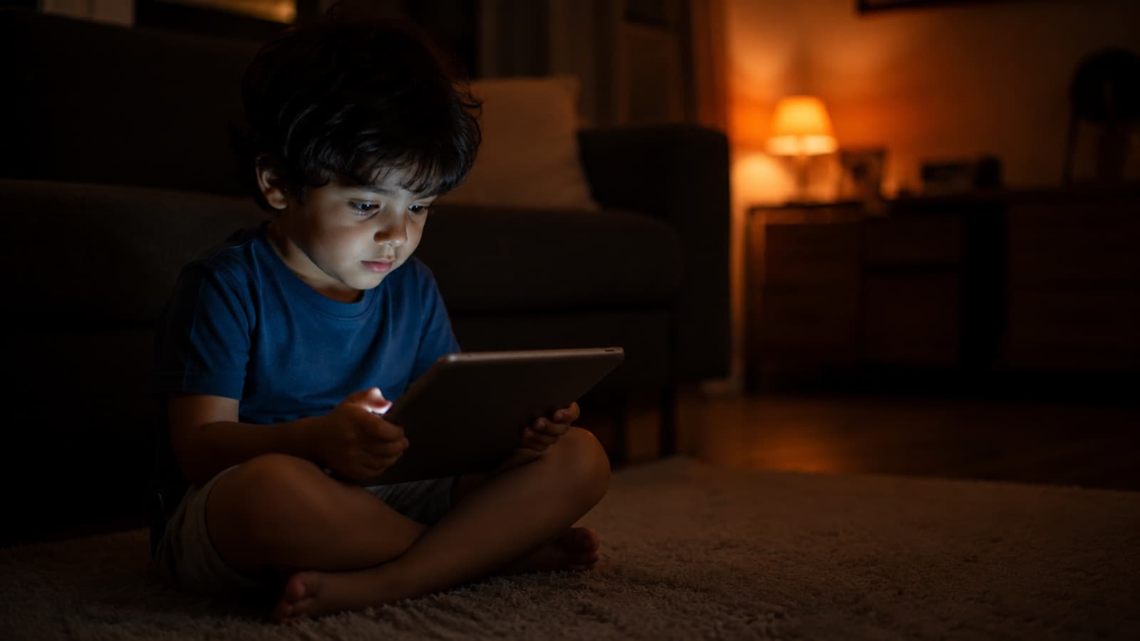 Criança assistindo a um vídeo no tablet, rosto iluminado pela tela